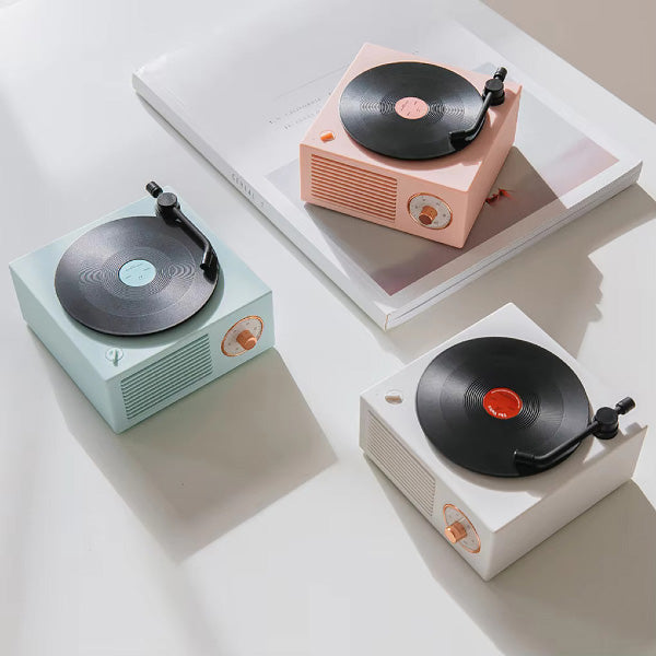 Små retroinspirerade bluetooth-högtalare som liknar vinylspelare i olika pastellfärger.